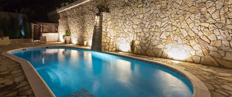 Lighting along a stone wall near a pool in Huntsville, AL.