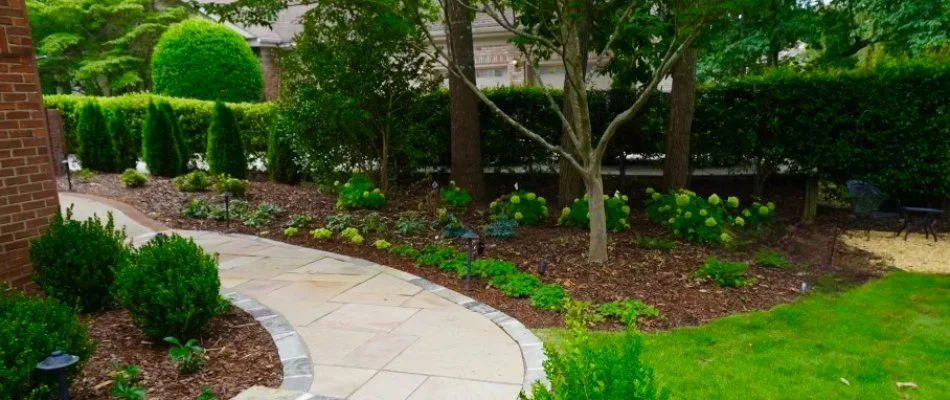 Mulched landscape in Huntsville, AL, with shrubs, flowers, and trees.