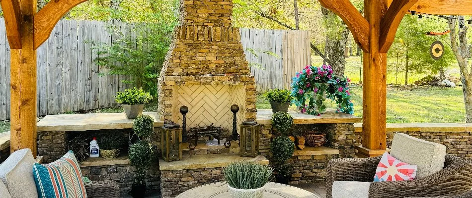 Stone outdoor fireplace under a pavilion in Huntsville, AL.