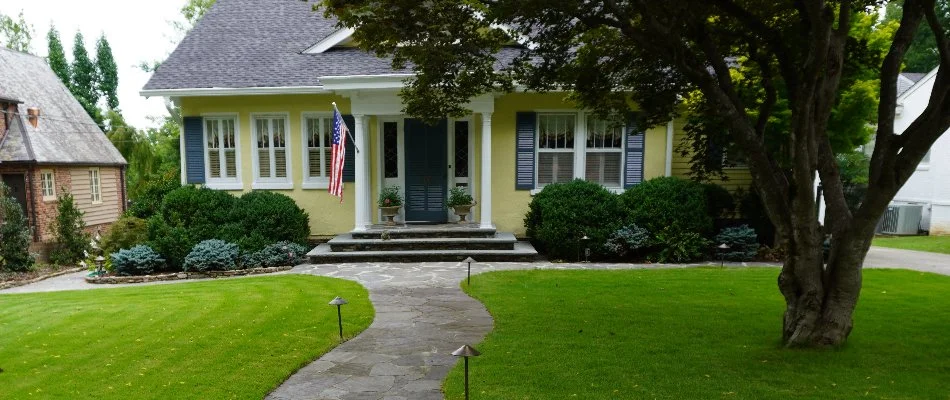 Yard in Huntsville, AL, with grass, shrubs, and a tree.