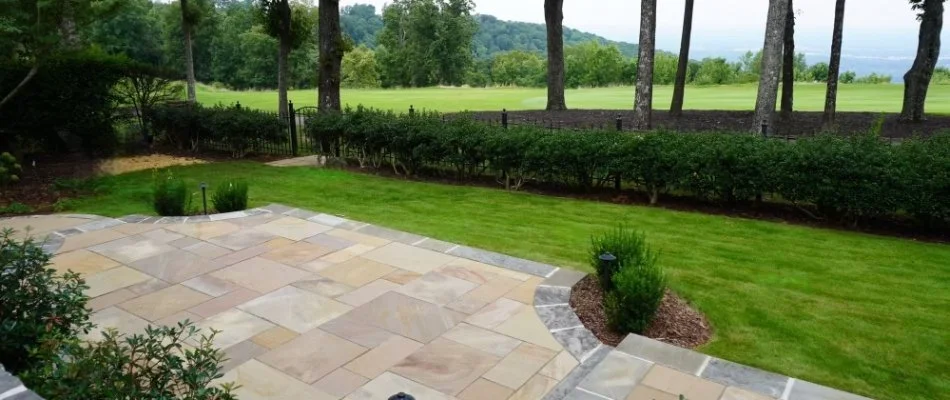 Backyard with patio, green lawn, and plants in Olde Cobblestone, AL.