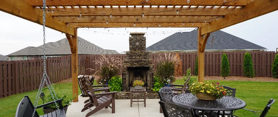 Outdoor fireplace under a pergola in Huntsville, AL.