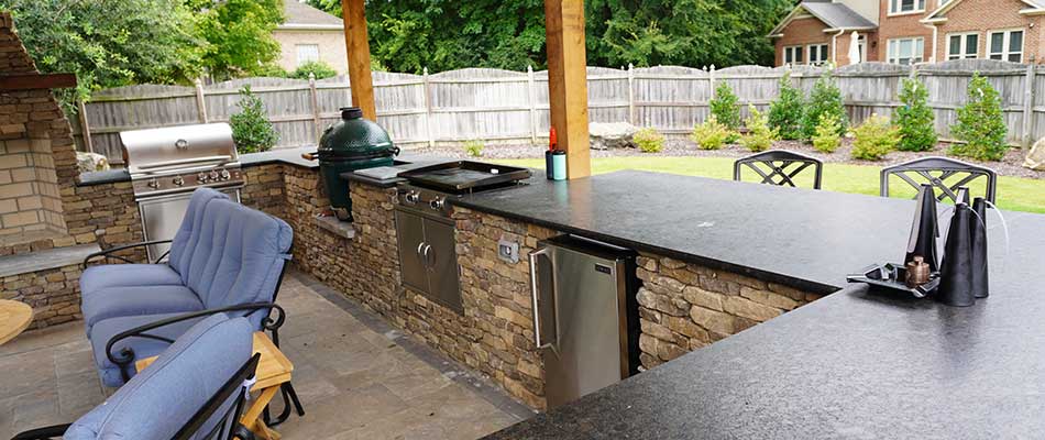 Custom outdoor kitchen with countertops, sinks, and grills near Huntsville, Alabama.